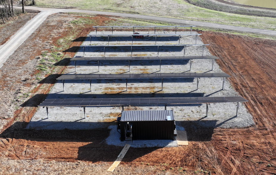 Ground-mounted solar array connected to containerized off-grid power system